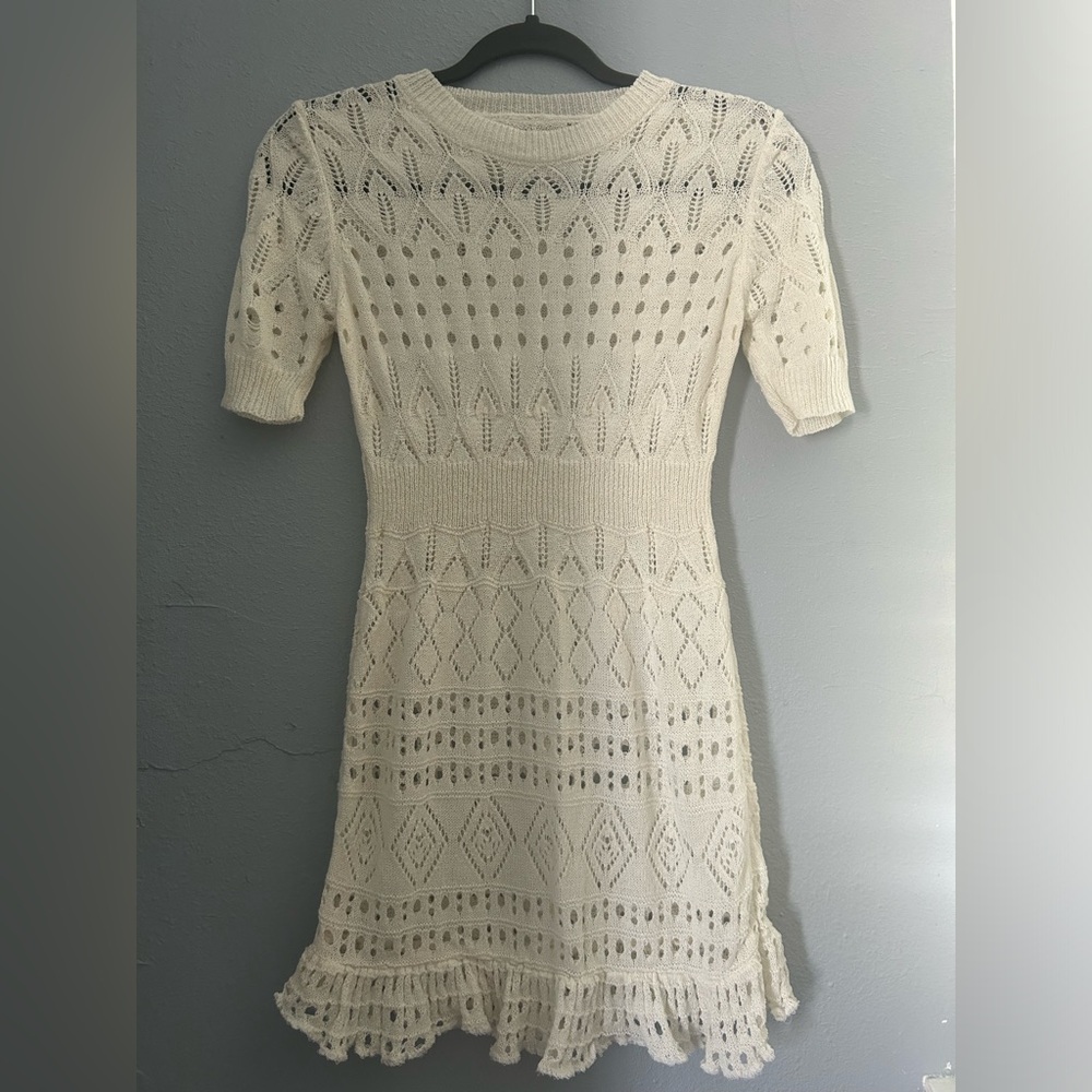 Cream and white knit dress with a stretchy fit .